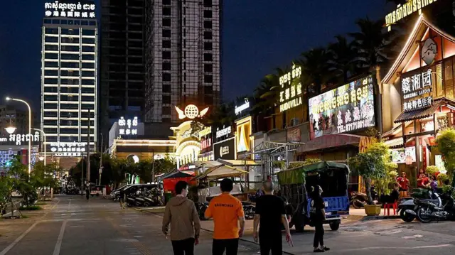 Esta foto, tomada el 8 de abril de 2025, muestra a gente paseando frente a restaurantes y tiendas chinas en Sihanoukville.