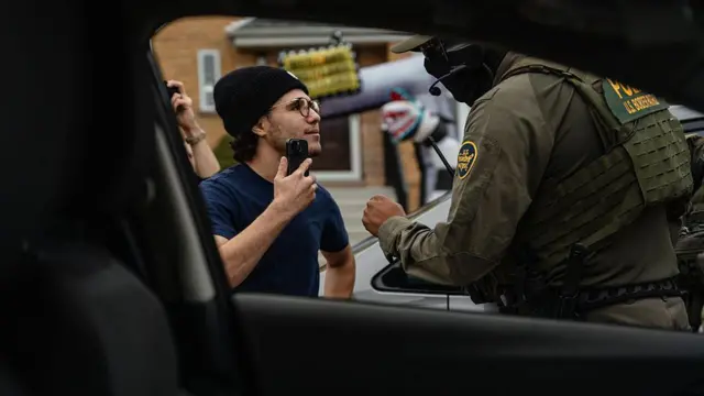 Un joven enfrenta a agentes federales después de que arrestaran a un trabajador en una casa de su vecindario Edison Park el 31 de octubre de 2025 en Chicago, Illinois. Los agentes le dieron dos advertencias y amenazaron con arrestarlo por interferir en su operación durante la 