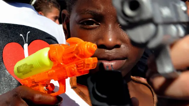 Niño juega con armas de juguete en un acto simbólico en Medellín en 2009.