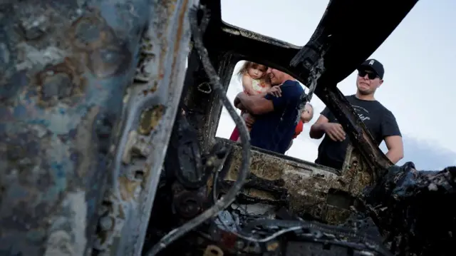 Familiares de las víctimas del ataque contra nueve miembros de las familias LeBaron, Langford y Miller junto a una de las tres camionetas calcinadas en Bavispe, Sonora, el 5 de noviembre de 2019. REUTERS/Jose Luis Gonzalez