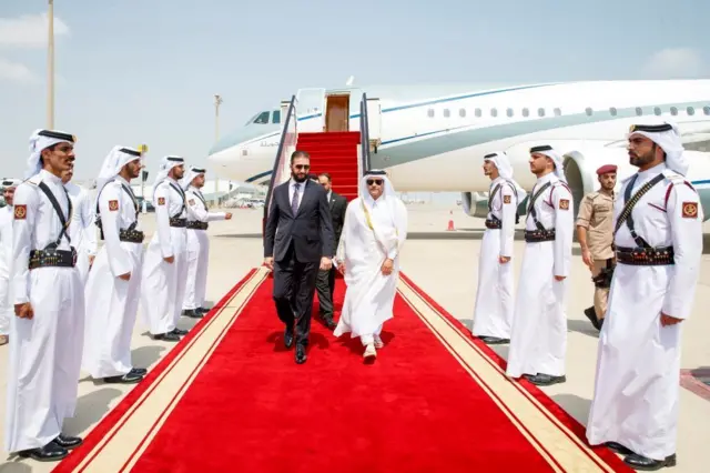 El presidente sirio, Ahmed al Sharaa, camina sobre la alfombra roja después de desembarcar de un avión en Doha antes de una cumbre de emergencia de líderes árabes-islámicos.