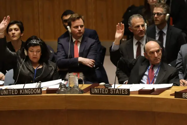 Elliott Abrams alza la mano en una votación del Consejo de Seguridad de Naciones Unidas. Está sentado como representante de Estados Unidos junto a la represetante británica.
