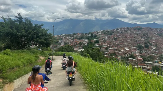 Turistas en motos bajando por una colina. 