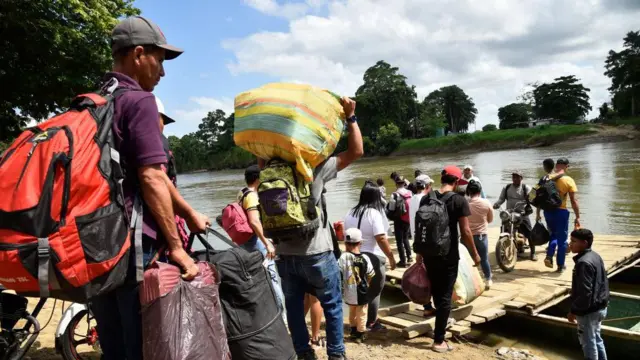 Desplazados cruzan el río Tarra tras la crisis de violencia en el Catatumbo.