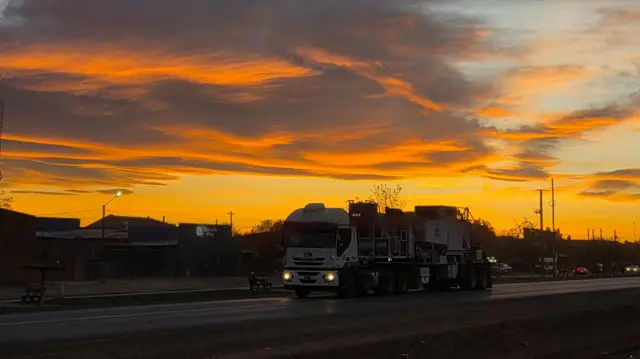 Atardecer en una ruta por donde pasa un camión