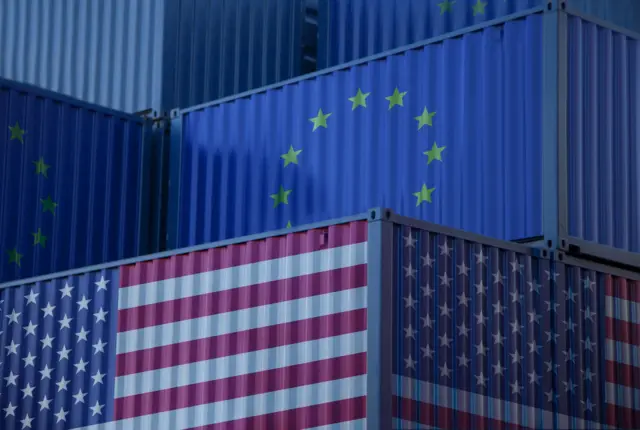 Imagen de unos containers con las banderas de la UE y de EE.UU.