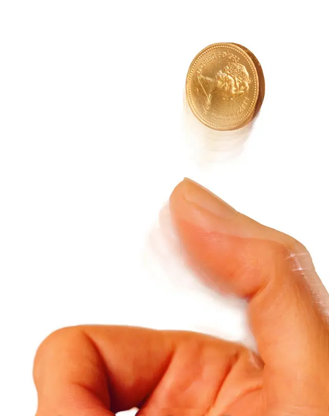 Mano tirando una moneda al aire