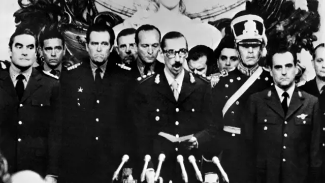 Videla rodeado de otros militares durante la ceremonia de juramentación en 1976