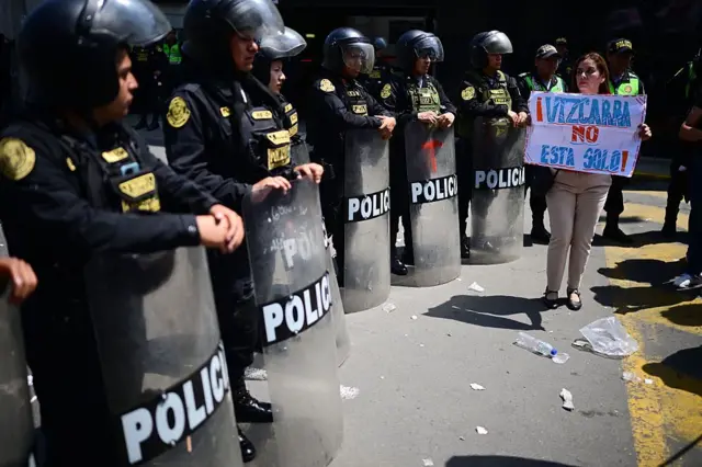 Una manifestante sostiene un cartel en el que dice 