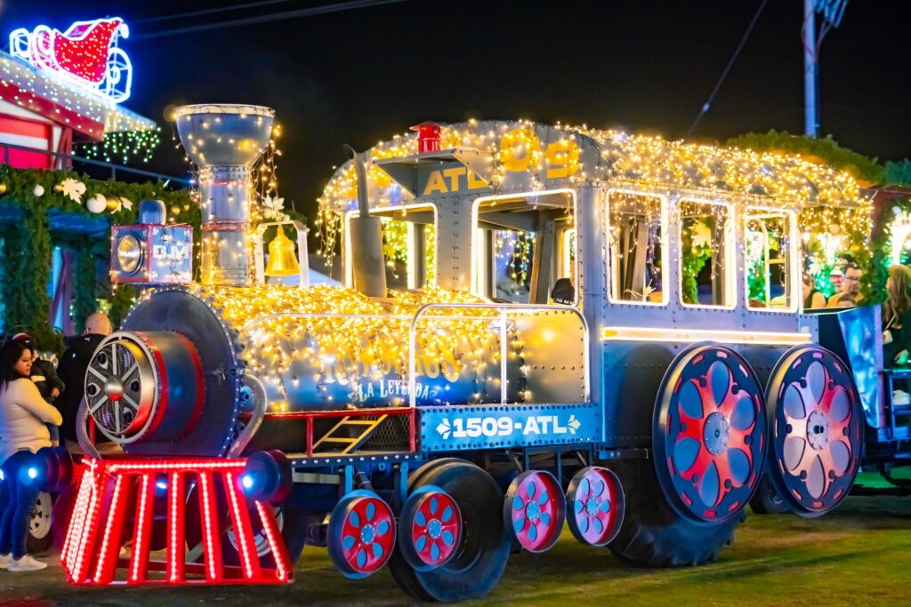 El tren navideño recorre los escenarios iluminados para que disfrutes cada rincón del festival.