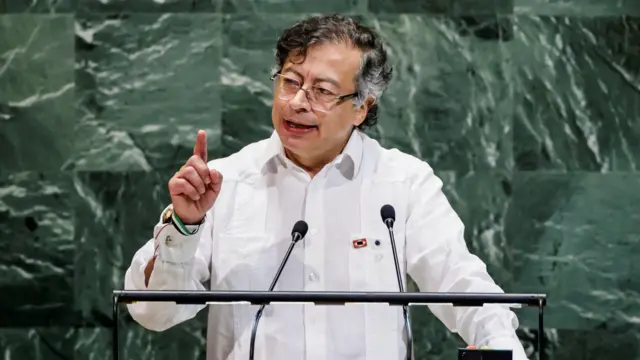 El presidente Petro habla y apunta con su dedo índice mientras da un discurso desde un atril.