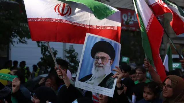 Una mujer sostiene un cartel del líder supremo iraní, el ayatolá Alí Jamenei, en una manifestación el 14 de junio de 2025, en Teherán, Irán.