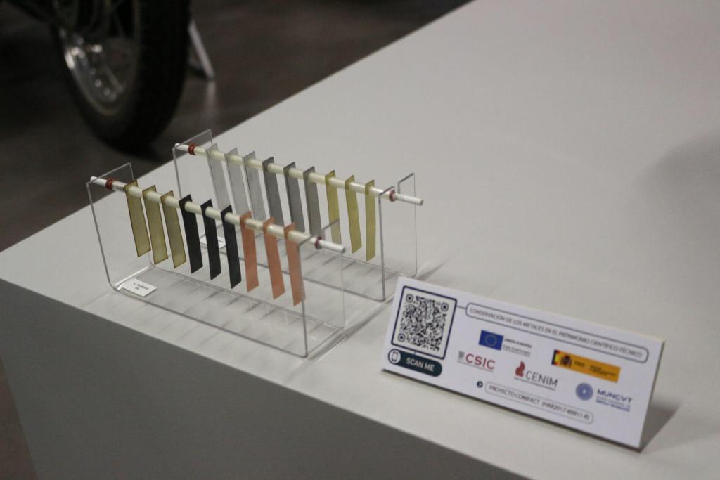  Ejemplo de bastidor con distintos dosímetros de plata, plomo, cobre, acero, aluminio y latón que fueron colocados en la sala “Ruedas” del Museo Nacional de Ciencia y Tecnología (MUNCYT) en su sede de Alcobendas, Madrid junto a una cartela explicativa del proyecto de investigación llevado a cabo. Créditos: María Teresa Molina y Emilio Cano