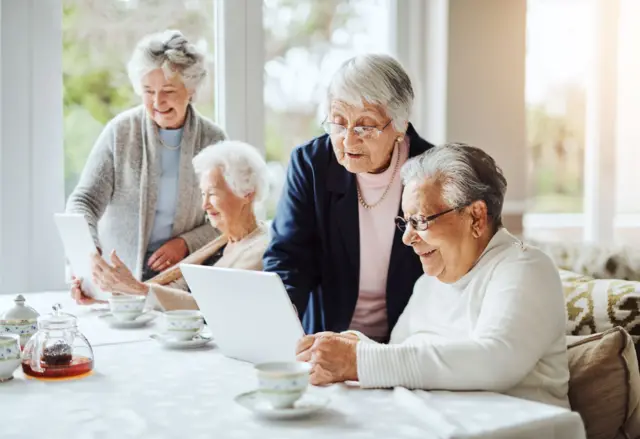 Mujeres de mayor edad se divierten aprendiendo a usar dispositivos digitales