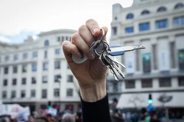 Primer plano de una mano que sujeta un puñado de llaves. 