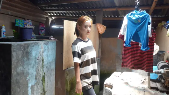 Esti Agustina con una camiseta y pantalones en lo que parece ser un baño exterior