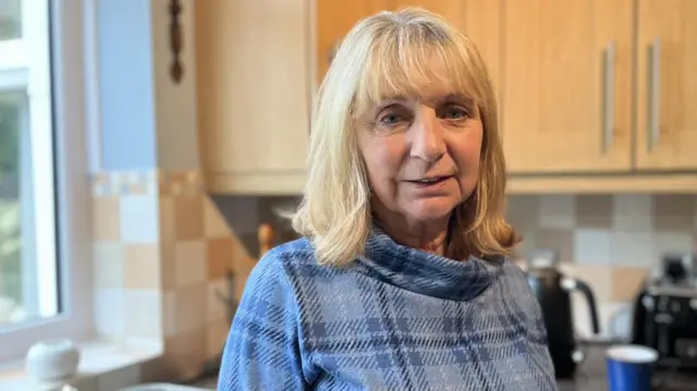 Diane Debens con una camisa azul en su cocina.