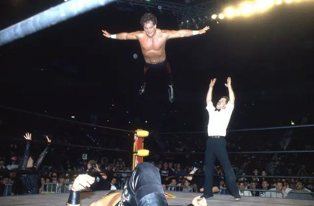 Chris Benoit, acaba de saltar de lo más alto de la tercera cuerda y va a aterrizar de cara en el pecho de su oponente, en su reconocida movida final. 