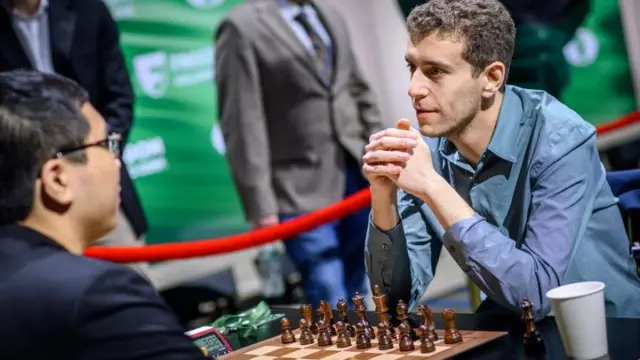 Naroditsky jugando al ajedrez con espectadores detrás.