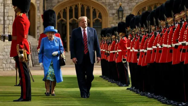 Donald Trump camina junto a la reina Isabel II de Inglaterra, mientras ambos pasan revista a la Guardia Real británica formada con su tradicional uniforme rojo y negro en el castillo de Windsor. 