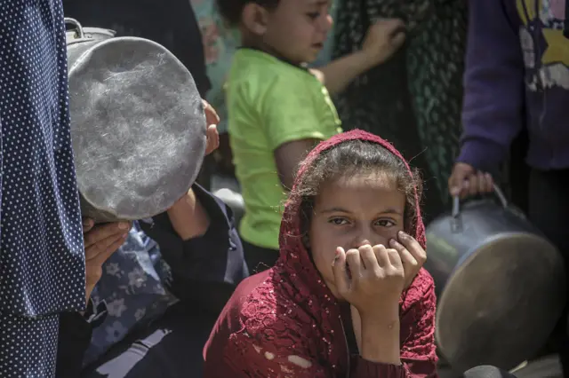 Una niña parece cansada y preocupada mientras espera recibir alimentos de una cocina benéfica en el campo de refugiados de Yabalia, en el norte de Gaza, 9 de mayo de 2025