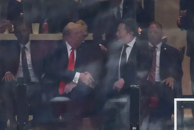 El presidente de Estados Unidos, Donald Trump, y el director ejecutivo de Tesla, Elon Musk, se dan la mano durante el servicio conmemorativo público del activista de derecha Charlie Kirk en el State Farm Stadium en Glendale, Arizona, el 21 de septiembre de 2025.