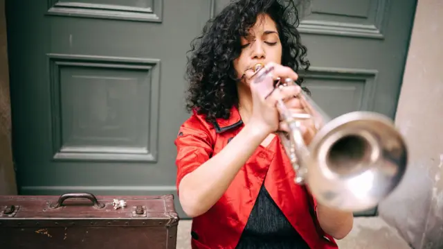 Mujer tocando la trompeta.