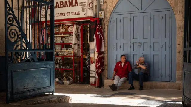 Dos hombres hablan en la puerta de un comercio en Jerusalén Este. 