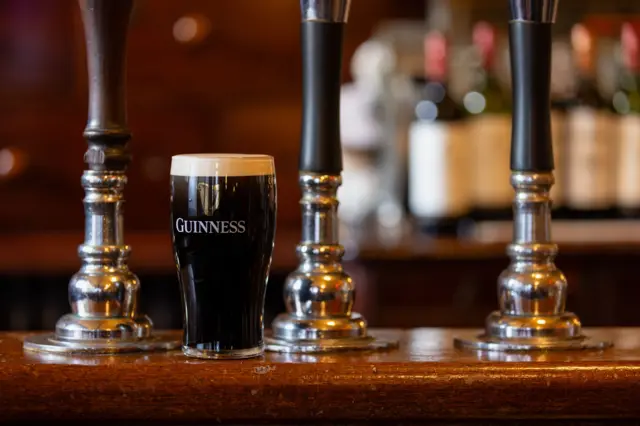 Un vaso de cerveza Guinness sobre una barra de un bar