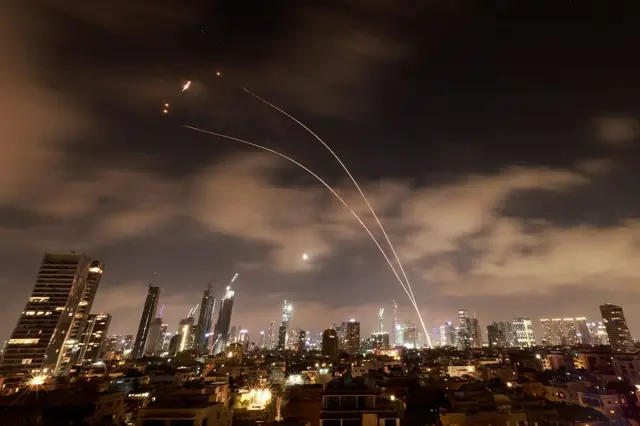 Los sistemas de defensa aérea israelíes se activan para interceptar misiles iraníes sobre la ciudad israelí de Tel Aviv el 18 de junio de 2025.