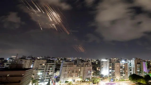 Estelas de luz en el cielo sobre Ashkelon, Israel, mientras las defensas aéreas operan contra los misiles iraníes, 1 de octubre de 2024