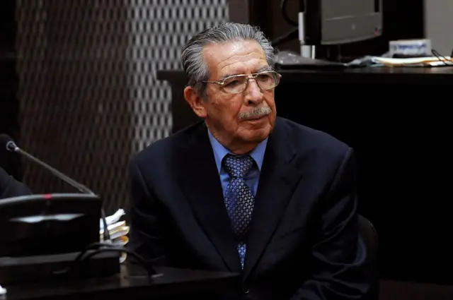 Efraín Ríos Montt, un hombre de edad, con bigote y anteojos, sentado en un tribunal durante un juicio