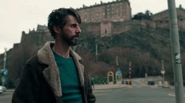 Un hombre con barba en mitad de la calle. 