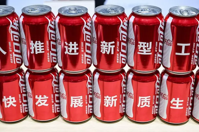 Varias latas de Coca Cola una encima de otra