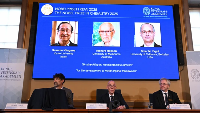Miembros del Comité del Nobel con una pantalla detrás que muestra los rostros de los tres ganadores del Premio Nobel de Química