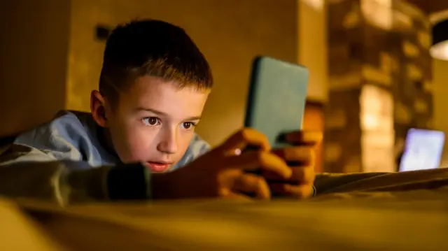 Un niño con un teléfono celular. 