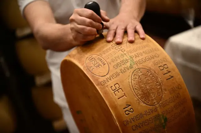 Un trabajador corta una rueda de queso Parmigiano Reggiano en la Casearia Castelli, miembro del Grupo Lactalis, en el Caseificio Tricolore en Reggio Emilia, norte de Italia