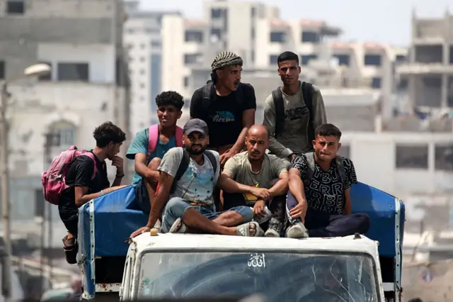 Hombres palestinos viajan en una camioneta de transporte público en la Ciudad de Gaza el 8 de agosto de 2025. 