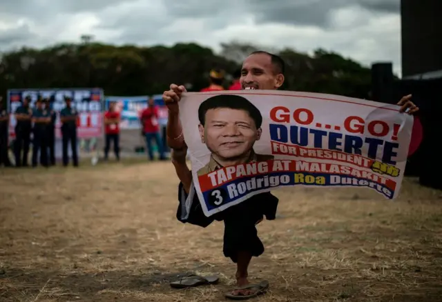 Una persona lleva el cartel de Duterte. 