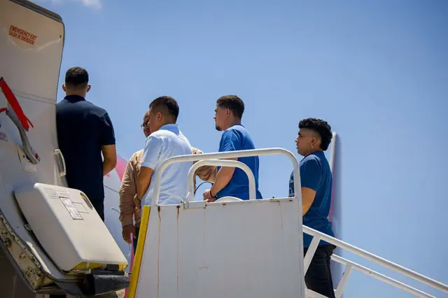 Venezolanos entregados por el gobierno salvadoreño, en la escalerilla del avión que los llevó a Venezuela.