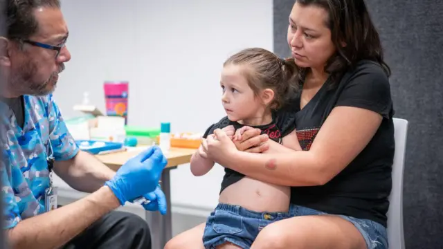 Un médico vacuna a una niña en Texas