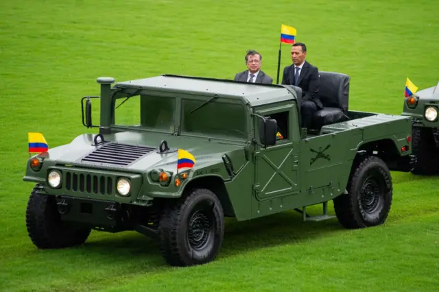 Gustavo Petro y su ministro de Defensa, Pedro Sánchez, a bordo de un vehículo militar adornado con banderas de Colombia.