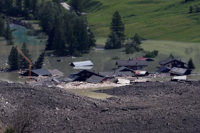 Vista de casas destruidas y tapadas por agua el 29 de mayo de 2025, después de que un deslizamiento masivo de rocas y hielo cubriera la mayor parte del pueblo de Blatten, Suiza.