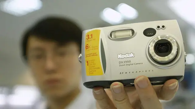 Un dependiente sostiene una cámara digital Kodak en unos grandes almacenes de Pekín