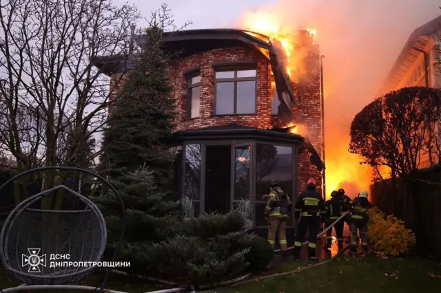 Bomberos tratan de apagar un edificio en llamas. 