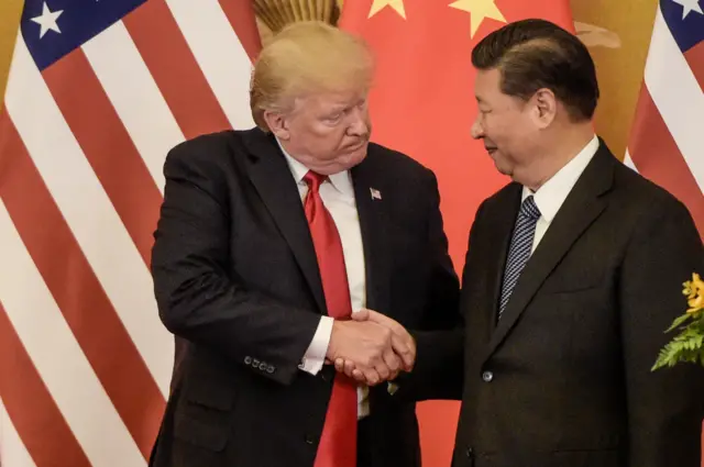 Trump estrecha la mano de Xi Jinping con las banderas de sus países detrás