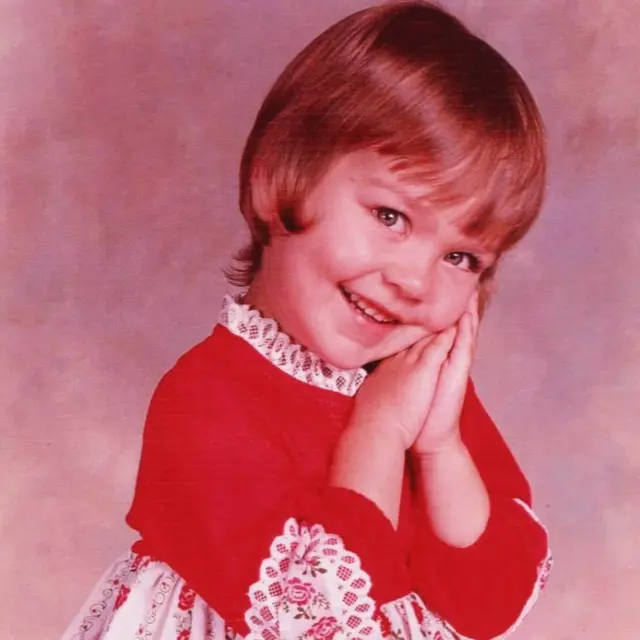 Alexis sonriendo y vestida de rojo