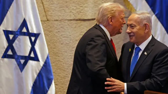 El presidente de Estados Unidos, Donald Trump (i), habla con el primer ministro israelí, Benjamín Netanyahu, en el Parlamento de Israel el 13 de octubre de 2025.