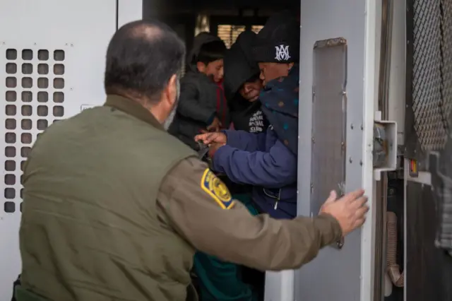 Un guardia de la Patrulla Fronteriza cierra un vehículo con migrantes