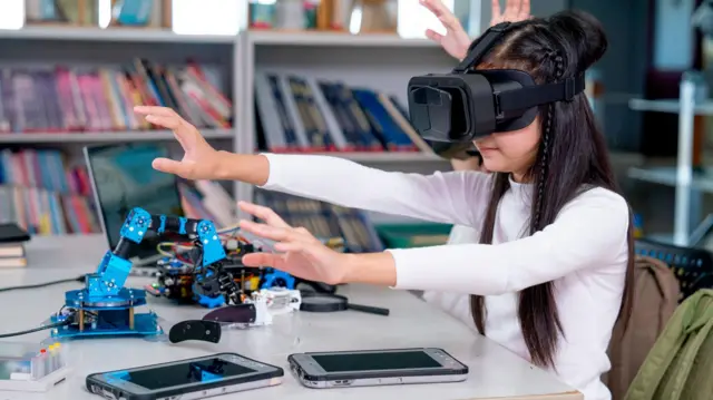 Dos niñas con gafas de realidad virtual en la clase de robótica de primaria.